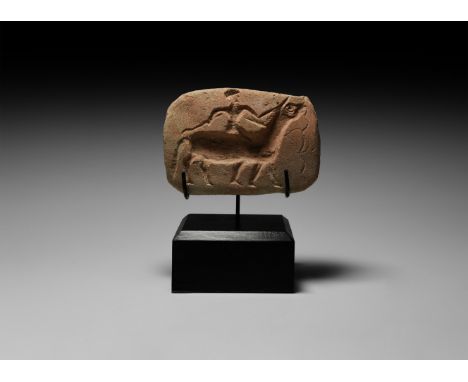 18th century BC. A carved terracotta master for a ceramic plaque depicting a scene of a rider on horseback holding a whip abo