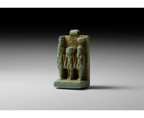 Late Period, 664-332 BC. A light green glazed composition amuletic pendant depicting the standing sacred triad of Isis with t