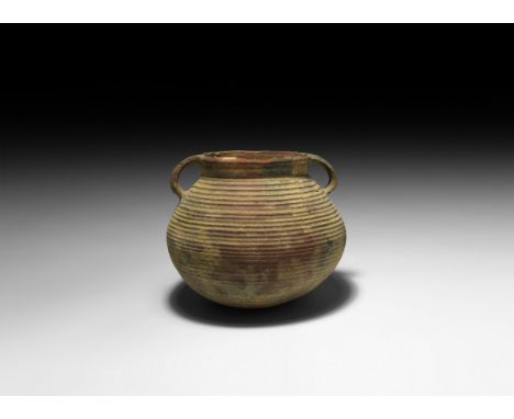 1st century BC-1st century AD. A bulbous ceramic jar with ribbed outer face, two looped handles.  341 grams, 16cm width (6 1/