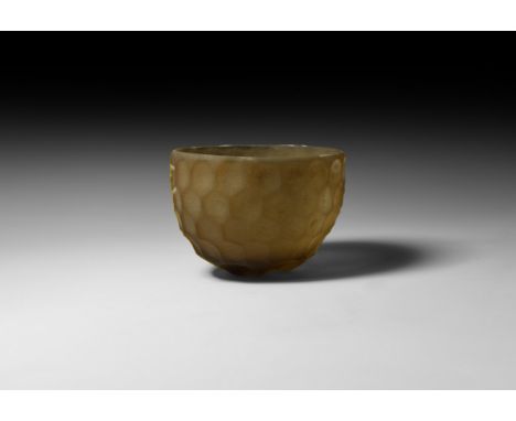5th-6th century AD. A glass hemispherical cup with wheel-cut facets in five tiers, shallow indented base, rounded rim. Cf. Wh
