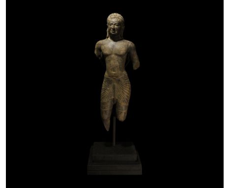 11th-14th century AD. A carved sandstone figure of Buddha standing, wearing a carefully draped sanghati, hair tiered in radia
