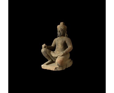 12th-13th century AD. A carved sandstone figure of a crouching Yaksha, or Tree Guardian, wearing a pleated kilt and braided h