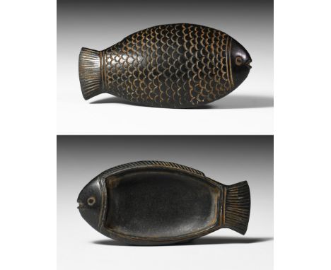 New Kingdom, 1550-1070 BC. A carved black jasper cosmetic palette representing a fish with incised eyes and detailed scales. 