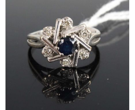 A white metal, sapphire and diamond set flower head cluster ring, indistinctly marked but tests as 18ct gold, 5.5g, size M