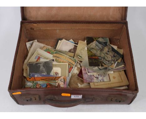 A vintage brown leather suitcase containing a collection of Victorian and later postcards to include topographical and satiri