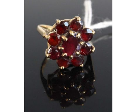 A modern 9ct gold and garnet set flower head cluster ring, setting dia.17mm, 3.7g, size K