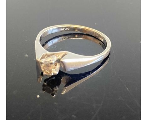 A white metal diamond solitaire ring, the four-claw set brilliant weighing approx 0.16 carats, stamped 10k and tests as appro