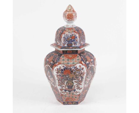 An early 20th century vase of cover, of hexagonal baluster form, decorated in the imari palette with vases issuing flowers, w