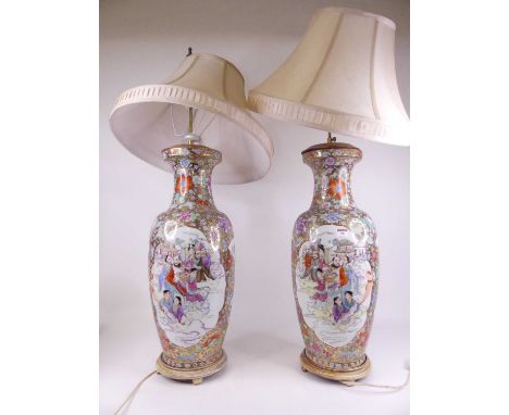 A pair of large Chinese export vases, each of shouldered baluster form, enamel decorated with figures within landscapes, on a