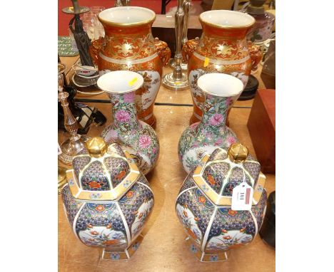 A pair of Japanese Meiji (1868-1912) Kutani vases, each of baluster form with lion mask handles, on an orange ground heighten