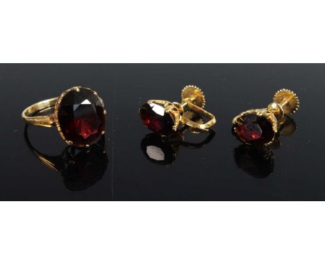 An 18ct gold garnet set dress ring, the oval cut garnet measuring approx 14 x 11.7mm, size M; together with matching ear clip