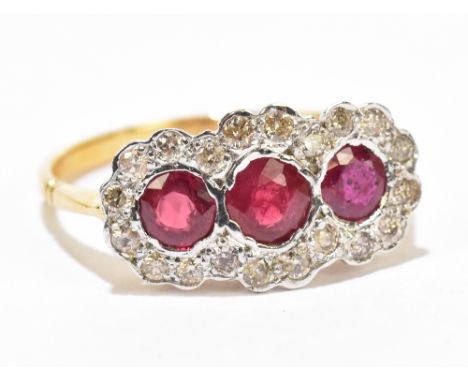 An 18ct yellow gold diamond and ruby dress ring with three central rubies surrounded by melee diamonds, approx size L, approx