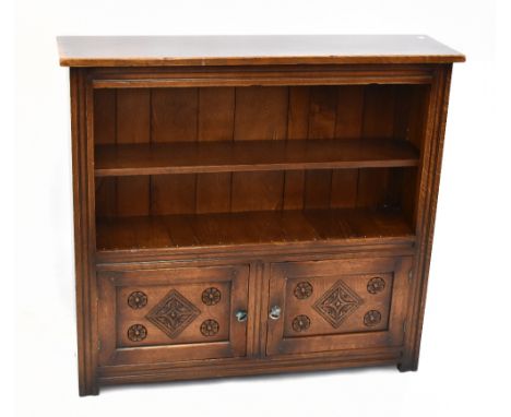 A reproduction oak bookcase with single adjustable shelf above two panelled cupboard doors raised on block feet, width 106cm,