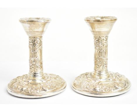A pair of hallmarked silver dwarf candlesticks, decorated throughout with scrolls and foliage, London 1972, height 10cm.Addit