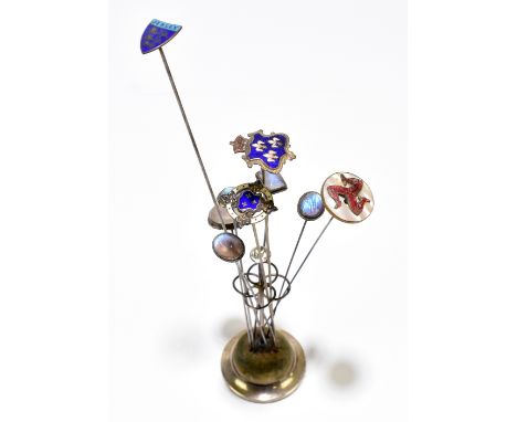 CHARLES HORNER; a hallmarked silver hat pin stand containing eight hat pins including an Isle of Man example, three enamelled