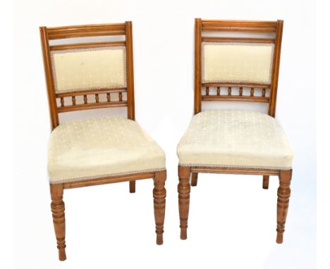 A set of five Edwardian golden oak dining/salon chairs, comprising four singles and one with arms, with turned spindle suppor