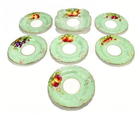 EDWARD TOWNSEND FOR ROYAL WORCESTER; a seven piece part dessert service, hand painted with fruit on a mottled green ground, c