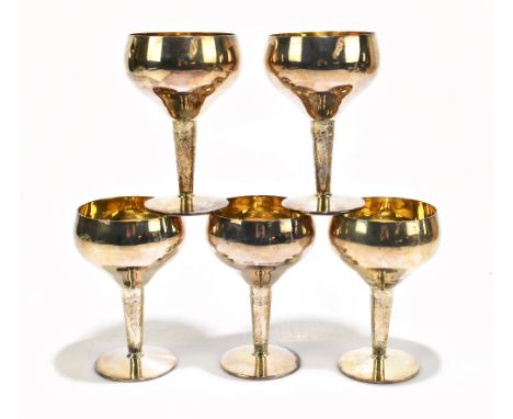 BERT GORDON; a set of five Elizabeth II hallmarked silver goblets, with gilded interiors, raised on floral decorated stems, B