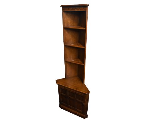 ERCOL; a medium elm free standing corner cabinet with open shelf back above single panel door, height 195cm, width 68cm.