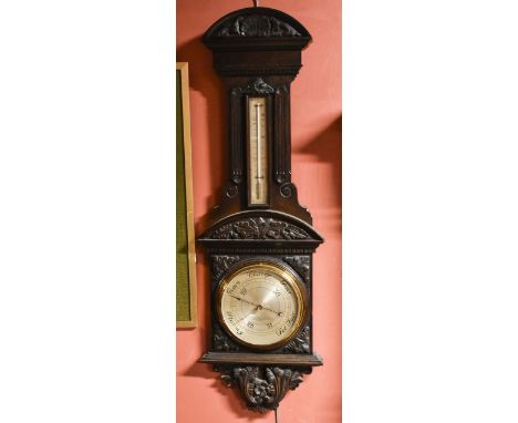 A late Victorian carved oak aneroid barometer, the silvered dial signed 'Thomas Armstrong &amp; Bros Ltd', height 103cmAdditi