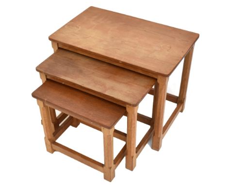 ROBERT MOUSEMAN THOMPSON; a nest of three adzed oak coffee tables, raised on chamfered block supports, width 60cm, depth 37cm