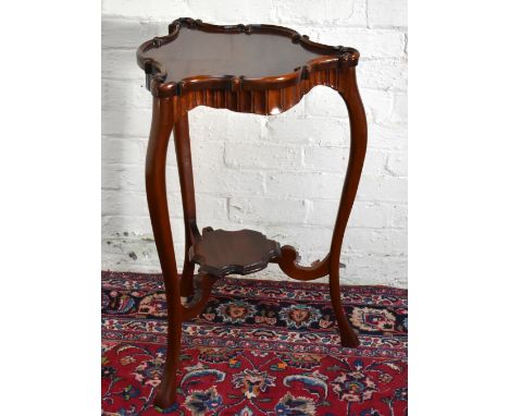 A reproduction triangular shaped occasional table, with applied pie crust edge above undertier shelf, height 83cm.&nbsp;