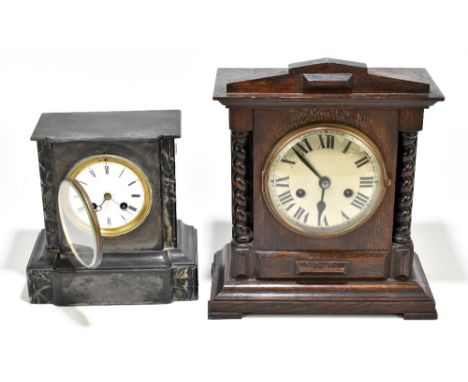 A late 19th century French black slate mantel clock, height 22cm and an early 20th century oak mantel clock, height 32cm (2).