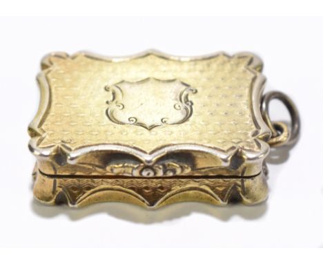 NATHANIEL MILLS; a Victorian hallmarked silver gilt vinaigrette of shaped rectangular form with engine turned decoration surr