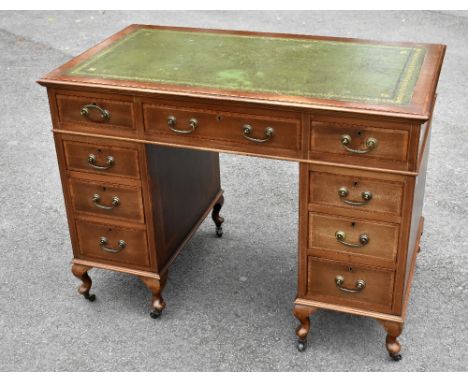 An Edwardian inlaid mahogany pedestal desk with an arrangement of nine drawers on cabriole legs, height 78cm, width 107cm, de