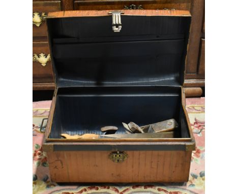 A collection of vintage tools including a Record plane, a brace, various saws, etc, contained in a tin trunk.