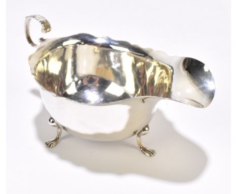 GEORGE NATHAN &amp; RIDLEY HAYES; a George V hallmarked silver sauce boat with scalloped edge, raised on three hoof feet, Che