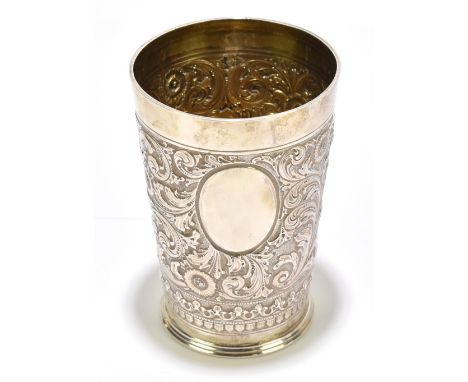 A late Victorian hallmarked silver and embossed beaker of good proportions, with vacant oval central cartouche and spreading 