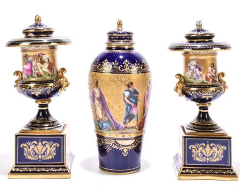 VIENNA; a pair of porcelain cobalt blue gilt heightend and hand painted urns and covers and a similar ovoid vase, the vase an