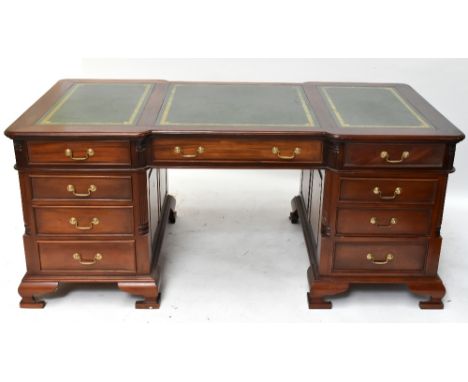 A reproduction hardwood partners' desk with three green leather inset panels to the top above an arrangement of nine drawers 