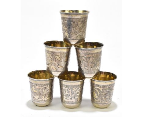 PAVEL OF OVCHINNIKOV (Moscow 1853-1916); a set of six silver vodka cups each with engraved floral decoration and traces of gi