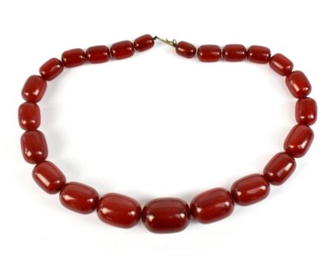 An early 20th century string of cherry amber graduated beads, length 46cm, the largest bead 30mm x 23mm, the smallest bead 14