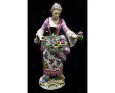 MEISSEN; an early 20th century figure of a young woman holding a basket of flowers, painted mark to base, impressed number 85