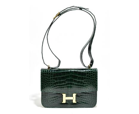 A dark green crocodile skin shoulder/handbag with a gold tone 'H' fastener and hardware, in the style of an Hermès Constance 