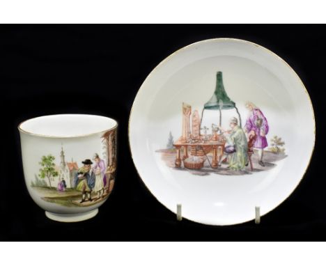 MEISSEN; a 19th century cup and saucer, the cup decorated with a couple standing beside a stall with four floral sprays paint