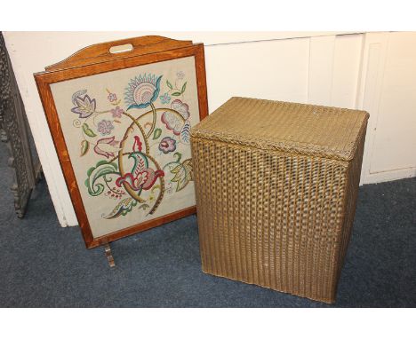 An oak framed fire screen with tapestry panel, together with a Lloyd Loom linen basket