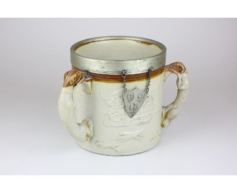 A 19th century stoneware three-handled trophy cup with silver plated rim and medallion, applied fox hunting and revelry decor