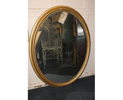 A 19th century oval wall mirror with carved wood and gesso gilt frame (a/f - over painted with bronze paint), 122cm by 95cm