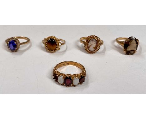 FIVE 9CT GOLD DRESS RINGS, blue sapphire and paste, size K, cameo, size O, smoky quartz, size M, tiger's eye, size N, opal an