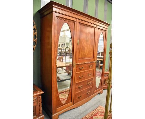 An Edwardian Inlaid Mahogany Wardrobe, the central cupboard above four drawers flanked by twin mirrored doors, 197cm by 61cm 
