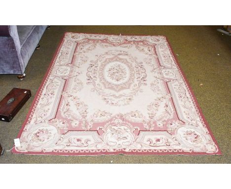 Needlepoint Rug of Aubusson Design, the cream field centred by an oval floral panel, surrounded by swags and acanthus leaf bo