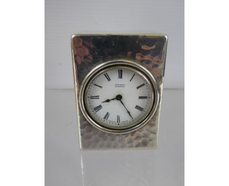 A Circa 1920's Asprey of London Silver Cased Travelling Clock, the clock having a hammered finish with white enamel face and 