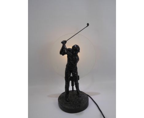 A Contemporary Composite Lamp Base, depicting a golfer in full swing, horizontal opaque glass shade.