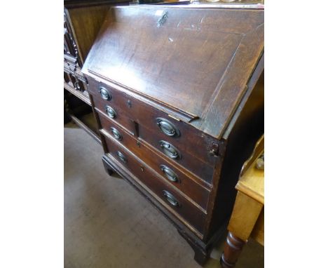 A Georgian Oak Drop Front Writing Bureau, with two short and two graduated long drawers, fitted interior, raised on bracket f
