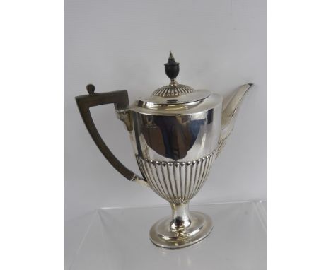 A Solid Silver Coffee Pot, the pot having a ribbed body, spout and lid with ebonised handle and finial, London hallmark dd 19