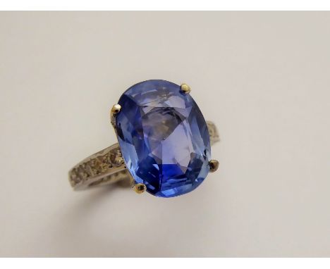 A 6.49 Carat Ceylon Non-Heat Treated Cornflower Blue Sapphire and Diamond Ring; the soft blue oval cut sapphire exhibiting a 